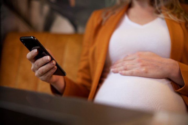 Raskaana oleva nainen käynnykkä kädessä
