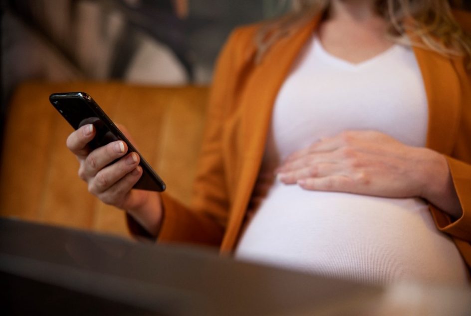 Raskaana oleva nainen käynnykkä kädessä